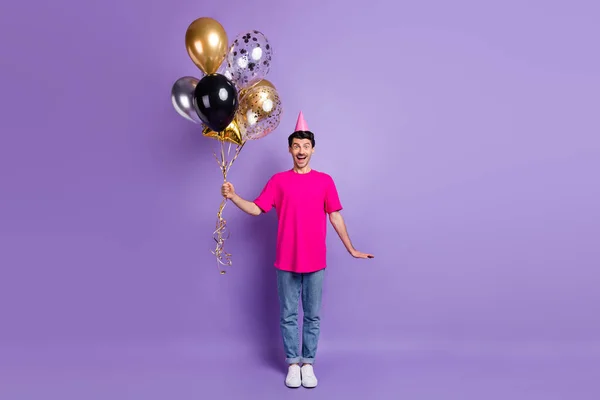 Foto de tamaño completo de chico guapo asombrado mano mantenga globos boca abierta sonrisa aislada sobre fondo de color violeta —  Fotos de Stock