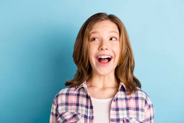 Foto de funky muito pequena menina usar camisa xadrez sorrindo boca aberta olhando espaço vazio isolado azul cor de fundo — Fotografia de Stock
