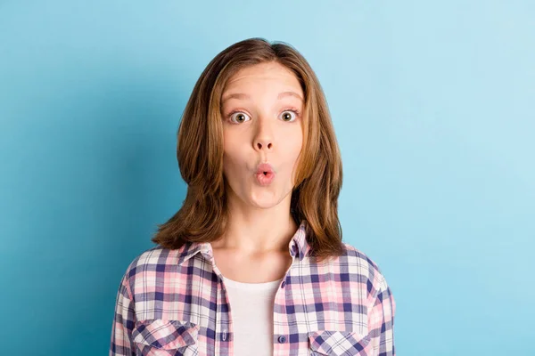 Foto de la encantadora chica de la escuela impactada usar camisa a cuadros ojos grandes aislado fondo de color azul —  Fotos de Stock