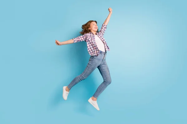 フルサイズ写真の若いです幸せな明るい笑顔興奮した女の子ジャンプ見るコピースペース隔離された上の青の色の背景 — ストック写真