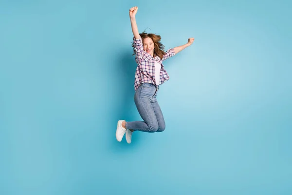 Volledige lengte portret van actieve opgewonden school meisje verhogen vuisten tand glimlach kijken camera geïsoleerd op blauwe kleur achtergrond — Stockfoto