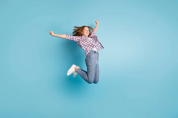 Foto em tamanho completo de pupila alegre levantar mãos punhos olhar espaço vazio tem bom humor isolado no fundo de cor azul — Fotografia de Stock