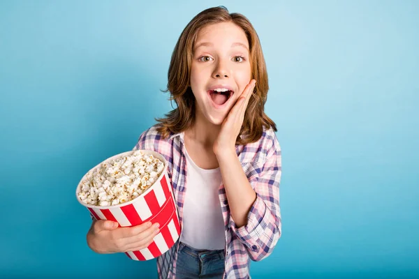 Photo of impressed red hairdo girl eat pop corn from wear shirt isolated on blue color background — Stock Photo, Image
