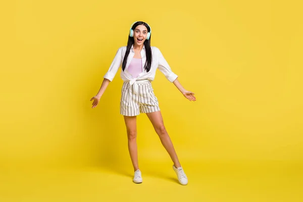 Volledige lengte foto van opgewonden jonge vrouw muziek liefhebber dragen koptelefoon geïsoleerd op gele kleur achtergrond — Stockfoto
