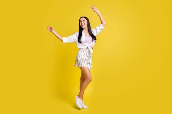Lunghezza completa foto di affascinante rilassato giovane signora sguardo spazio vuoto alzare le mani isolate su sfondo di colore giallo — Foto Stock