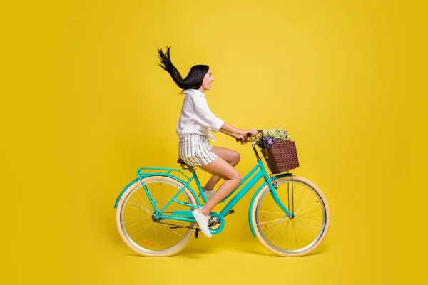 Foto lateral de perfil de tamaño completo de la mujer feliz excitada bicicleta mirada espacio vacío aislado en el fondo de color amarillo — Foto de Stock