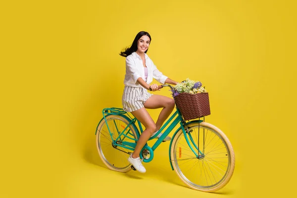 Mutlu ve güzel bir bayanın tam boy fotoğrafı bisiklet sürerken yaz havası sarı arka planda izole edilmiş. — Stok fotoğraf