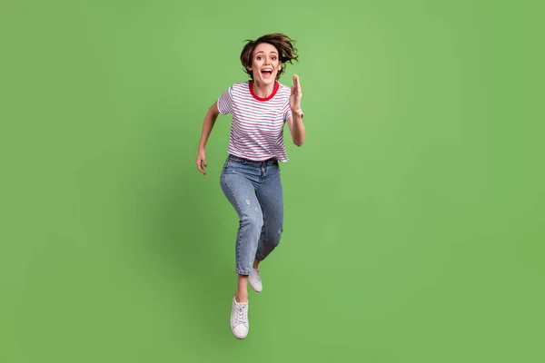 Comprimento total tamanho do corpo vista de menina muito alegre pulando movimento de corrida isolado sobre fundo cor pastel verde — Fotografia de Stock