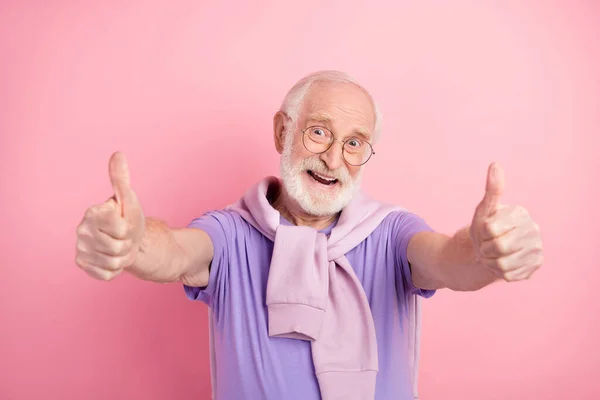 Foto retrato del anciano alegre y alegre mostrando el pulgar hacia arriba como signo aislado en el fondo de color rosa pastel — Foto de Stock