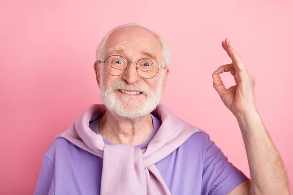Photo portrait of elder man cheerful man showing okay sign with fingers isolated on pastel pink color background