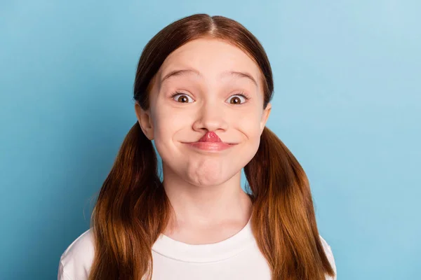 Ritratto di positivo spensierato scuola ragazza lingua toccare leccare naso guardare fotocamera isolato su sfondo di colore blu — Foto Stock