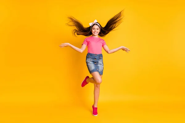 Photo of shiny pretty small schoolgirl dressed pink t-shirt jumping high dancing smiling isolated yellow color background — Stock Photo, Image