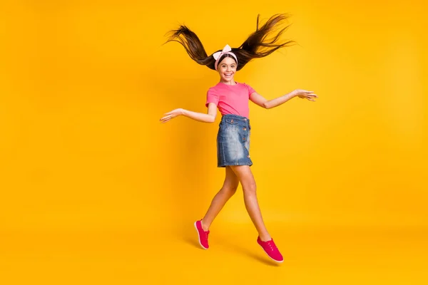 Photo of pretty adorable small schoolgirl dressed pink t-shirt jumping high dancing smiling isolated yellow color background — Stock Photo, Image