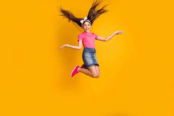 Zdjęcie podekscytowany uroczy uczennica nosić różowy t-shirt uśmiechnięty skoki wysoki izolowany żółty kolor tła — Zdjęcie stockowe
