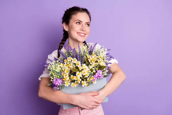 Foto de soñadora mujer joven bonita feliz mirada espacio vacío buen humor mantenga las flores aisladas sobre fondo de color violeta — Foto de Stock