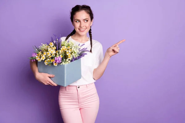 Retrato de pessoa muito positiva segurar flores silvestres olhar direto do dedo espaço vazio isolado no fundo cor roxa — Fotografia de Stock