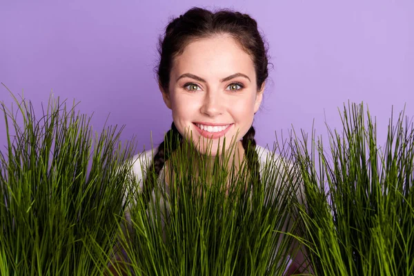 Foto de positivo feliz agradável jovem bom humor sorriso grama verde jardim isolado no fundo cor roxa — Fotografia de Stock