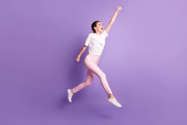 Фотографія збудженої безтурботної дівчини, яка піднімає кулак руки, дивіться вгору порожній простір ізольовано на фіолетовому кольоровому фоні — стокове фото