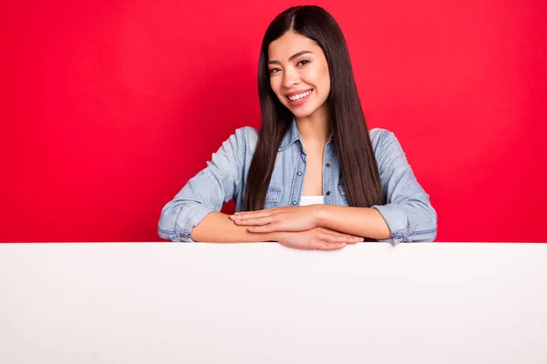 Portret van vrij vrolijk meisje met groot bord bureau promo promotie cadeau aanwezig geïsoleerd over helder rood kleur achtergrond — Stockfoto