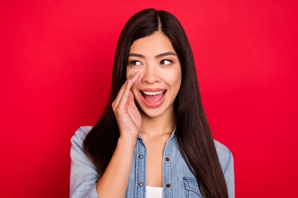 Zdjecie młody atrakcyjny azjatycki dziewczyna szczęśliwy pozytywny uśmiech powiedzieć plotki aktualności reklama krzyczeć patrzeć puste miejsce izolowane nad czerwony kolor tło — Zdjęcie stockowe