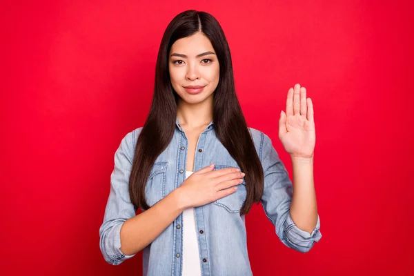 Porträt von attraktiven ruhigen Mädchen beten zeigt Palme geben Versprechen isoliert über leuchtend rote Farbe Hintergrund — Stockfoto