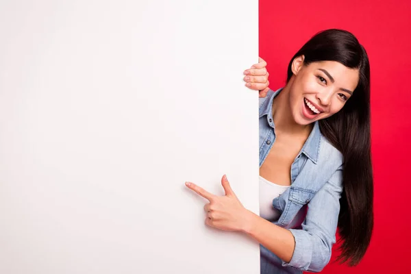 Muotokuva houkutteleva trendikäs iloinen tyttö osoittaa iso suuri tyhjä mainos uutta tietoa eristetty kirkkaan punainen väri tausta — kuvapankkivalokuva