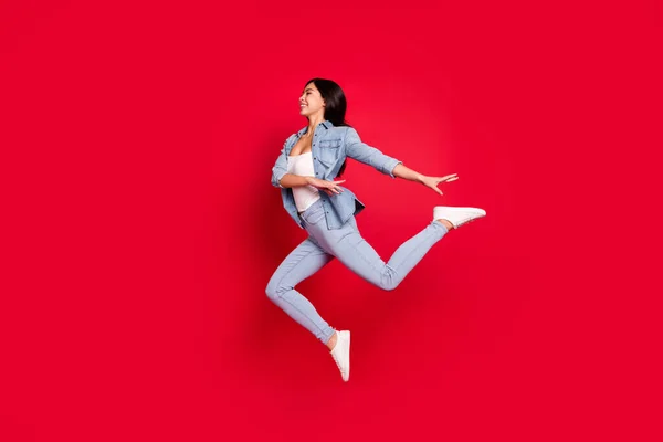 Tampilan ukuran tubuh penuh gadis yang ceria melompat menari modern terisolasi dengan latar belakang warna merah cerah — Stok Foto