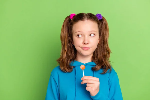 Genç kızın fotoğrafı boş görünüyor. El ele tutuşun. Yeşil arka planda izole edilmiş lolipop. — Stok fotoğraf