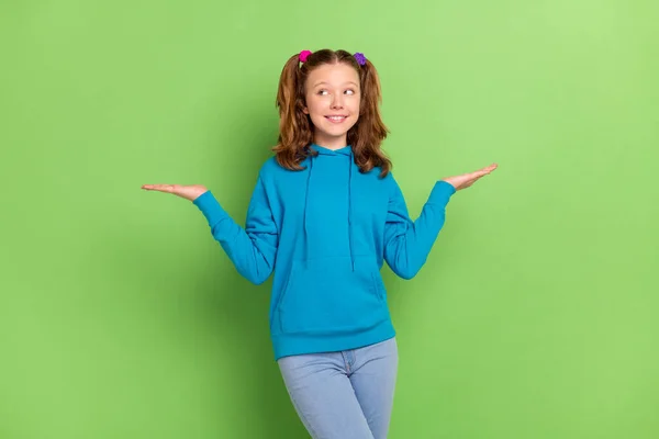 写真のブルネットの尾髪小さな幸せな女の子見て空のスペースホールド手スケール隔離された緑の色の背景 — ストック写真