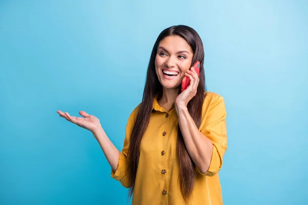 Foto retrato de mulher rindo falando no celular olhando para o espaço em branco isolado no fundo de cor azul brilhante — Fotografia de Stock