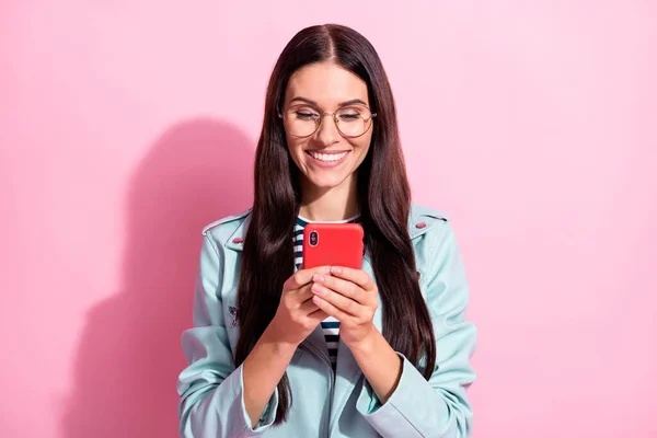 Foto di bella affascinante giovane donna sguardo smartphone leggere il messaggio isolato su sfondo di colore rosa — Foto Stock