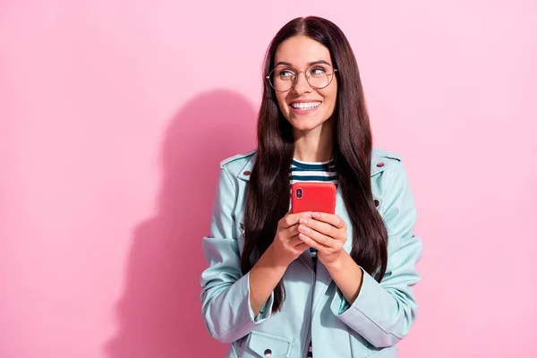 Foto di curiosa giovane donna felice tenere telefono look stand spazio vuoto isolato su sfondo di colore rosa — Foto Stock