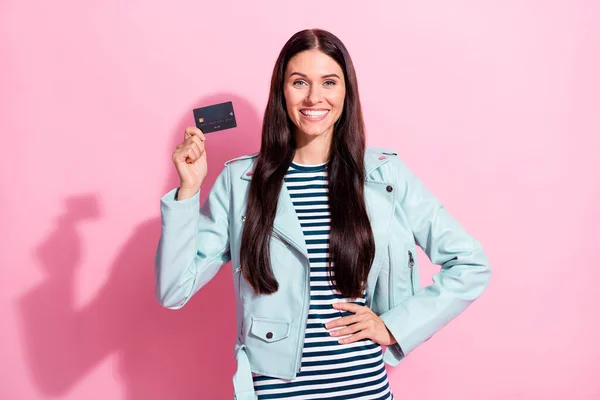 Foto de feliz mujer joven encantadora de la mano de la cintura de la tarjeta de crédito gastar dinero aislado en el fondo de color rosa —  Fotos de Stock