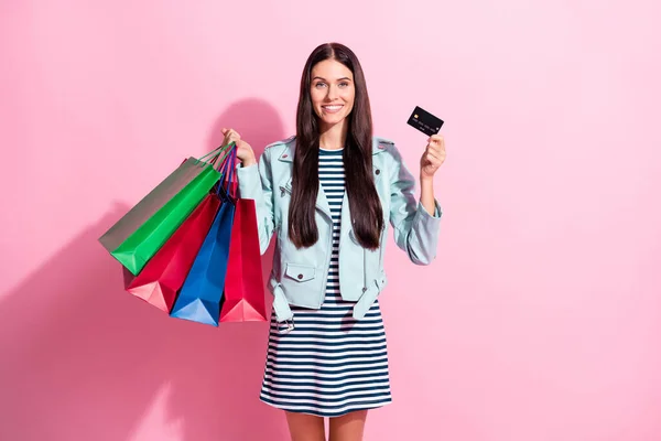 Foto de encantadora jovem senhora segurar sacos de compras de cartão de crédito isolado no fundo cor-de-rosa pastel — Fotografia de Stock