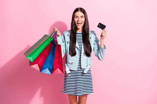 Fénykép izgatott fiatal barna nő hold bevásárló táskák betéti kártya eladó elszigetelt rózsaszín színű háttér — Stock Fotó