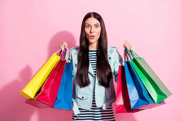 Φωτογραφία από έκπληκτος ωραίο χαριτωμένο νεαρή γυναίκα κατάπληκτος ψώνια πώληση κρατήσει τσάντες απομονώνονται σε ροζ φόντο χρώμα — Φωτογραφία Αρχείου