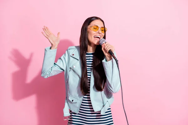 Фото мрійливої красивої леді в сонцезахисному окулярі співати мікрофон ізольовано на пастельному рожевому кольоровому фоні — стокове фото