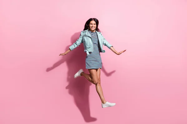 Foto in voller Länge von niedlichen charmante junge Mädchen gekleidet blaue Jacke springen hoch isoliert rosa Hintergrund — Stockfoto