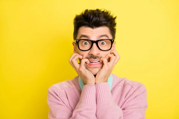 Foto van jonge knappe bang geschrokken gestresste man in glazen bijtende vingers geïsoleerd op gele kleur achtergrond — Stockfoto