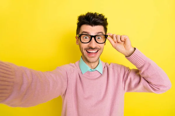 Fénykép a fiatal izgatott férfi boldog pozitív mosoly, hogy szelfi kéz érintőképernyős szemüveg elszigetelt sárga szín háttér — Stock Fotó