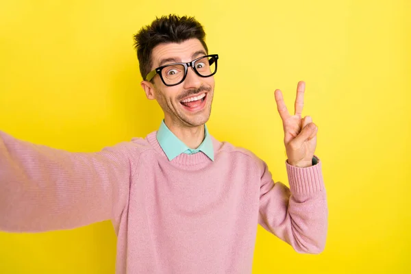 Foto von jungen aufgeregten Mann glücklich positives Lächeln machen Selfie zeigen Frieden cool V-Zeichen isoliert über gelben Farbhintergrund — Stockfoto