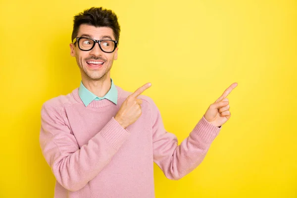 Фото молодої щасливої усміхненої мрійливої людини в окулярах точкова копія палець реклами ізольовано на жовтому кольорі — стокове фото