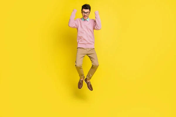 Foto de cuerpo completo del joven emocionado feliz sonrisa positiva emocionado regocijarse victoria saltar aislado sobre fondo de color amarillo —  Fotos de Stock