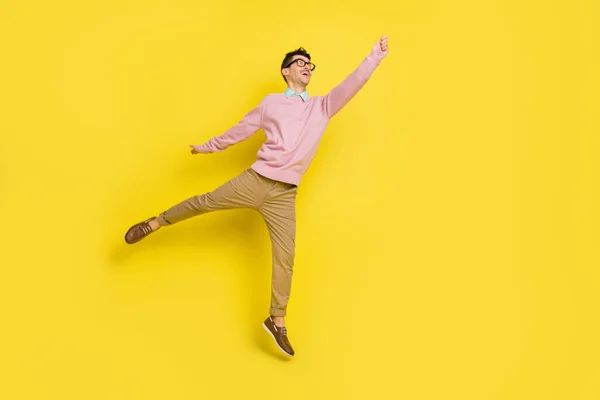 Full length φωτογραφία του νεαρού ενθουσιασμένοι άνθρωπος ευτυχής θετικό χαμόγελο άλμα επάνω προσπαθούν να πιάσουν ομπρέλα απομονώνονται πάνω από κίτρινο χρώμα φόντο — Φωτογραφία Αρχείου