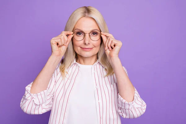 Bild av ganska charmig dam pensionär bära randig skjorta armar glasögon isolerad violett färg bakgrund — Stockfoto