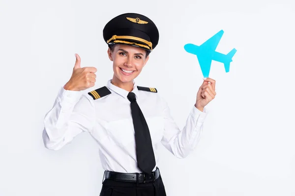 Fotografie hezké dívky držet papír letadlo zvednout palec nahoru nosit létavec klobouk uniforma izolované bílé barvy pozadí — Stock fotografie