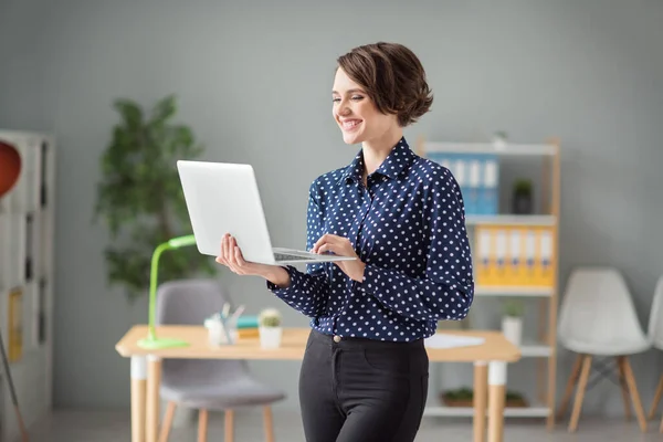 Porträtt av attraktiv fokuserad glad flicka håller i händerna med hjälp av laptop skriva webb det projektrapport på arbetsplatsen station inomhus — Stockfoto