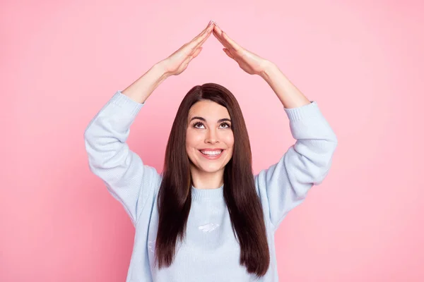 Фото гарного оптимістичного довгого волосся брюнетка дама показує, що дах носить синій светр ізольований на пастельному рожевому кольоровому фоні — стокове фото