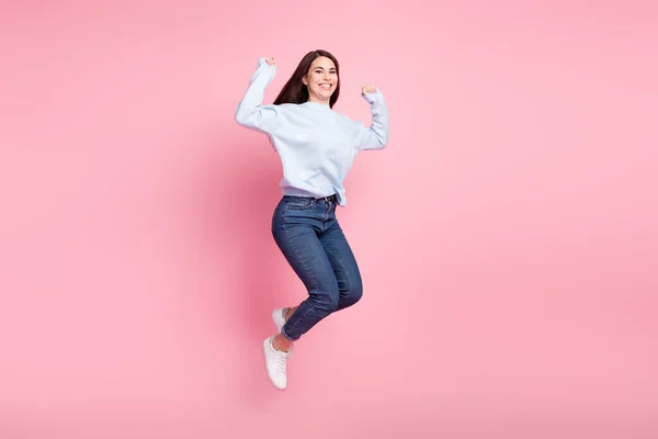 Foto de perfil de tamaño completo de bonito optimista pelo largo morena dama salto usar suéter azul aislado sobre fondo rosa —  Fotos de Stock