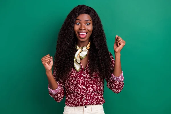 Foto de sorte engraçado ondulado escuro pele senhora desgaste impressão camisa levantando punhos sorrindo isolado cor verde fundo — Fotografia de Stock